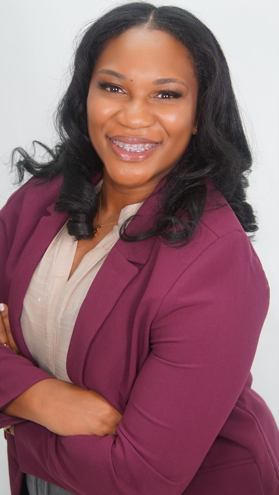 Quaneka Falls, founder of Harper McKenzie Consulting, wearing a plum blazer