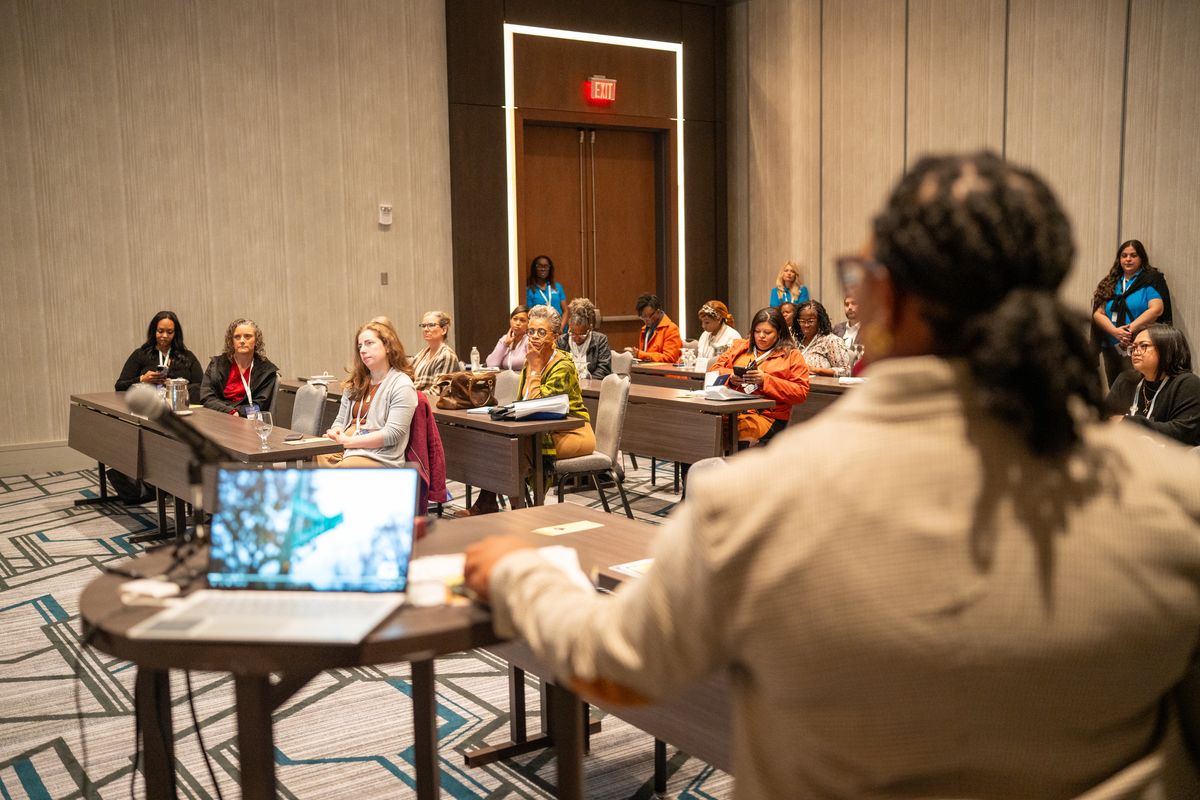 Quaneka Falls speaking from behind a podium at a professional event
